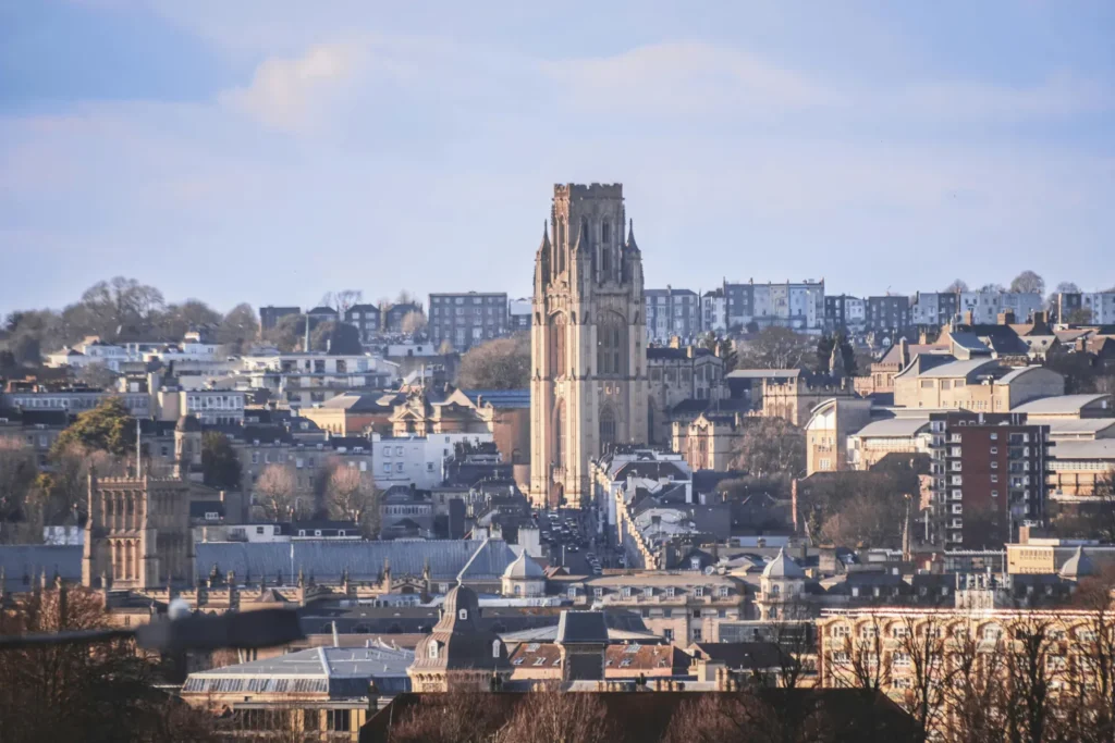 Cityscape of Bristol with a tall historic church tower rising above urban buildings