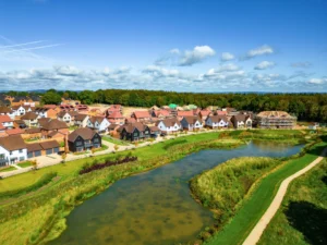 Aerial view of a housing development next to a pond and green space