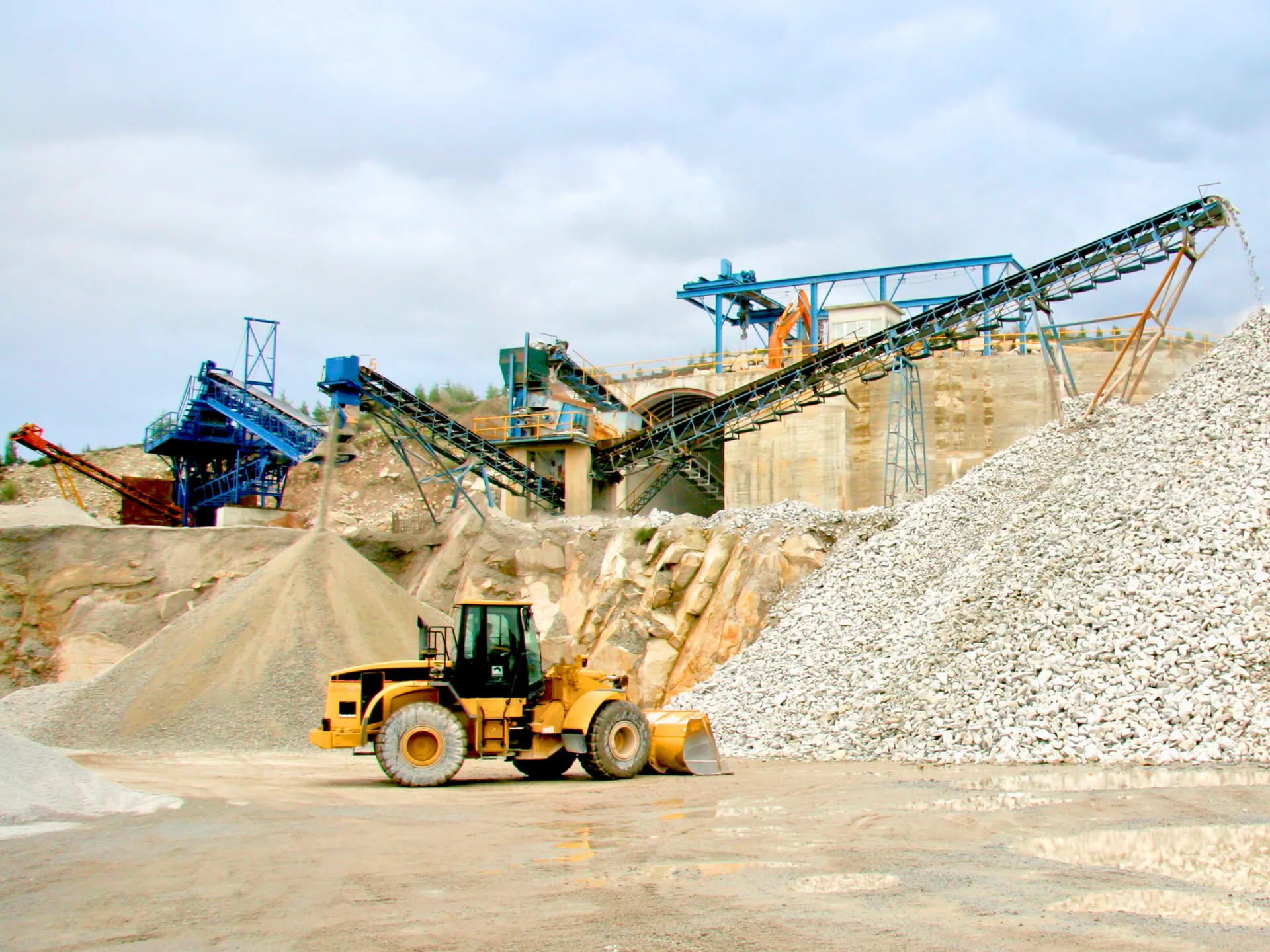 Loader vehicle moving gravel at quarry aggregate processing site