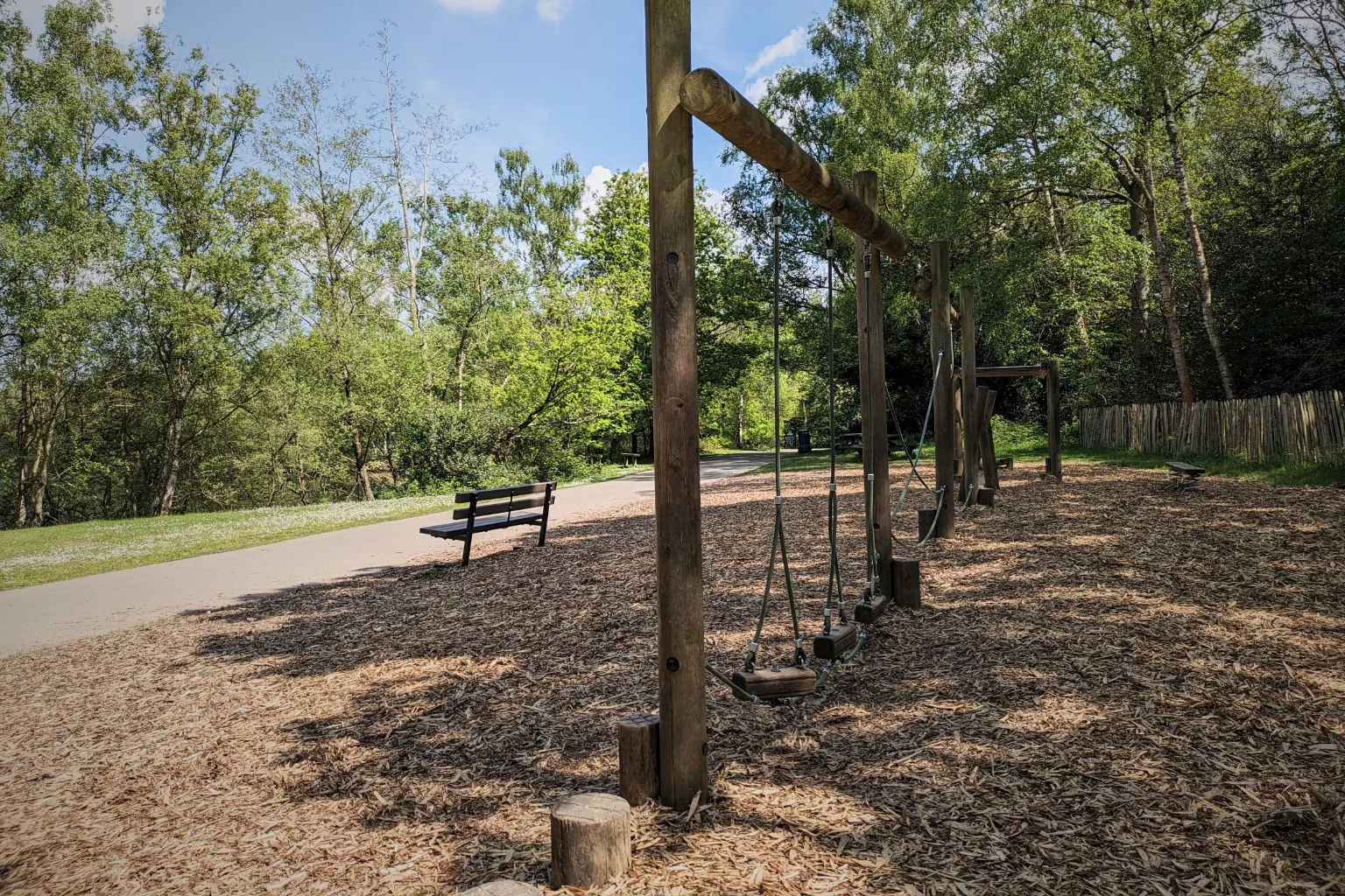 Wooden balance obstacle equipment in quiet park surrounded by trees